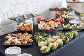 Beautifully decorated catering banquet table with different food snacks and appetizers.