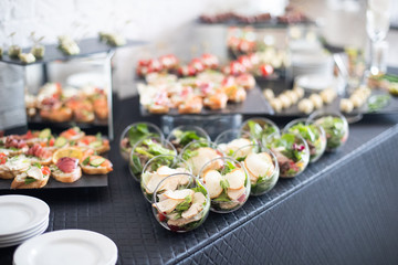 Beautifully decorated catering banquet table with different food snacks and appetizers.