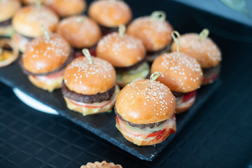 Hamburgers on the table. Little hamburgers on a tray. Food concept.