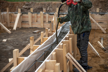 Construction workers are pouring a building foundation. - obrazy, fototapety, plakaty