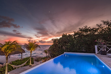 Fototapeta na wymiar Sunset over the sea from a house and swimming pool