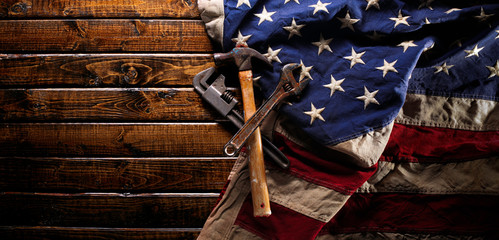 Old and worn work tools on large American flag - Labor day background
