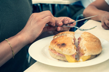 Man eating ham and cheese sandwich