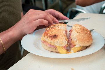 Man eating ham and cheese sandwich