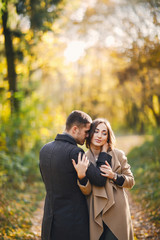 lovely couple walking around the park during autumn