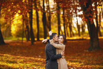 lovely couple walking around the park during autumn