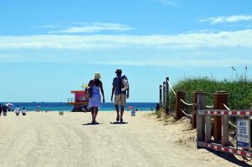 Young couple heading toward the beach in the south beach section of Miami Beach,Florida