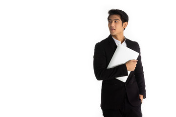 Handsome young businessman Asian caucasian wear a black suit with black hair, be a smile and standing smart poses. hold a computer laptop and use it. On a white background.