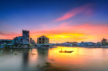 Naklejka premium Boatman rowing and transporting passengers across the river at sunset Mekong Delta in Soc Trang, Vietnam