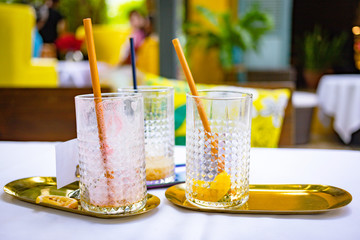 Empty glasses of fruit juice with paper straws on table