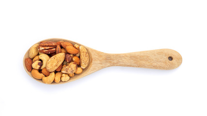 Baked mixed nuts in a wooden spoon on a white background.