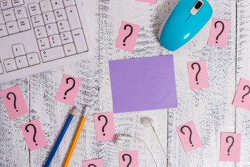 Writing tools, computer stuff and scribbled paper on top of wooden table