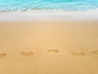 Footprints in sand on sea coast. Print on beach top view