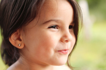 Fototapeta premium portrait of a cute little cheerful girl in the park outdoors