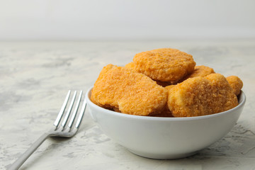 Chicken nuggets in a bowl on a light concrete table. fast food. close-up.
