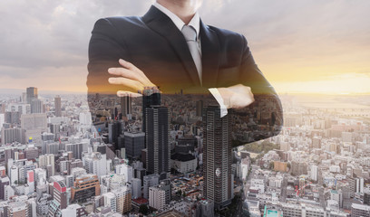 Business leader in black suit with arm crossed, Double exposure city in sunset
