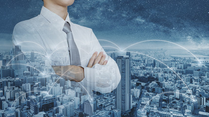Businessman in white shirt with arm crossed, double exposure futuristic city networking