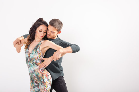 Young love couple dancing social danse kizomba or bachata over white background with copy space