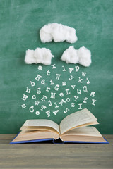 Education and reading creative concept rain of letters falls in to an open book, inspiration for a...