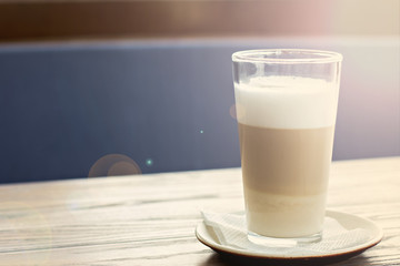 Latte glass on the table on the terrace of the summer cafe