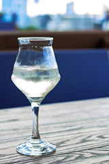 A glass of cold white wine on the table on the terrace of a summer cafe