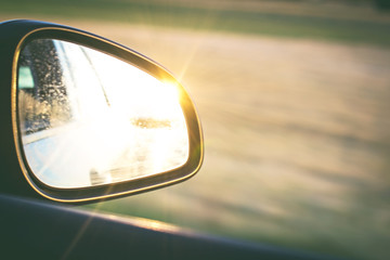 side mirror in a car in which the sunset is reflected.