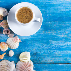 cup of coffee, shells, mobile phone on the old blue wooden boards.sea style. marine still life