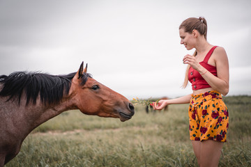 Obraz premium Smiling woman and brown horse