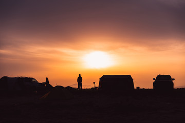 Fototapeta na wymiar Silhouette of a man standing in a camping site