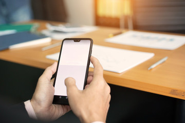 businessman hands searching for data on moblie phone with analyzing charts at his workplace.oncept