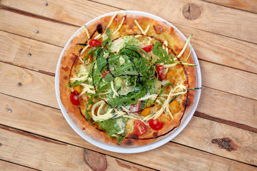 pizza with fresh vegetables on the wooden background