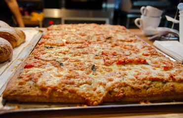 Rectangular pizza on tray for sale at small cafe
