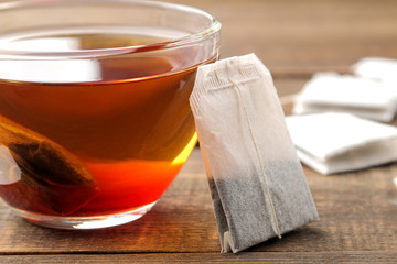 Tea bag in a glass cup on a brown wooden background. to make tea