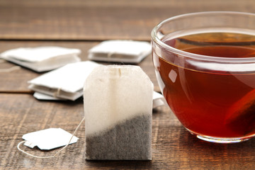 Tea bag in a glass cup on a brown wooden background. to make tea