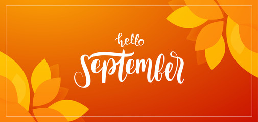 Autumn background with handwritten lettering of Hello September with fall leaves on orange background