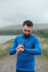 Handsome bearded man checking up his smart watch