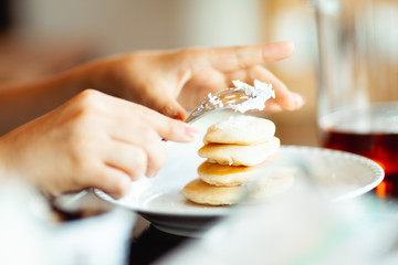 パンケーキにクリームとジャムをのせる手元