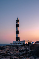 Blue hour view of the Cap Artrutx Lighthouse or Artrutx Lighthouse, an active 19th century lighthouse located on the low-lying headland of the same name on the Spanish island of Menorca.