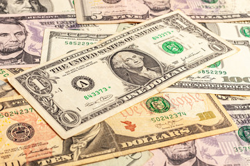 USA dollar bills. A few dollars of varying nominal values. Texture of multiple US dollar banknotes. Background from paper money. Close-up of multiple American dollar banknotes.