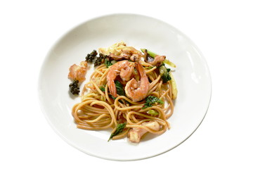 spicy stir fried spaghetti seafood with pepper and basil leaf on plate