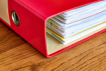 Red ordner with papers. Stack of business papers, bills or documents in ordner document binder...