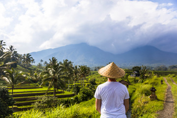 Man with traditional balinese cap at rice fields of Jatiluwih in southeast Bali