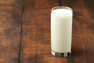 A glass with milk on a wooden rustic table