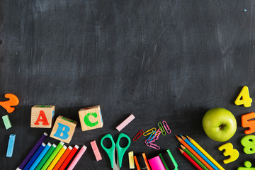 Back to school. School supplies on the background of the blackboard ready for your design. Copy space for text