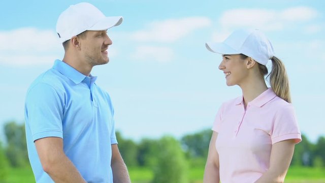 Professional golf players giving high five to each other after end of tournament