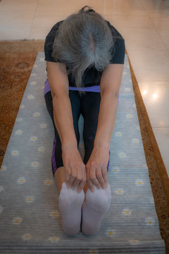 Senior Indian Woman Doing Yoga At Home Early In The Morning. India Has Been Suffering With A Surge Of Lifestyle Diseases Such As Diabetes And Hypertension. Only A Few People Are Taking Precautions .