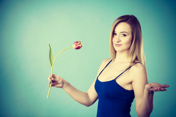 Shot on blue of woman holding tulip