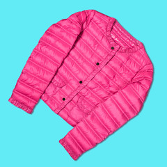 Women's pink autumn jacket on a turquoise background, concept