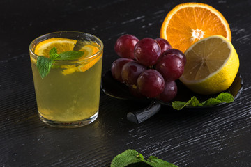 Fresh iced lemonad with slice of grape fruit on dark background