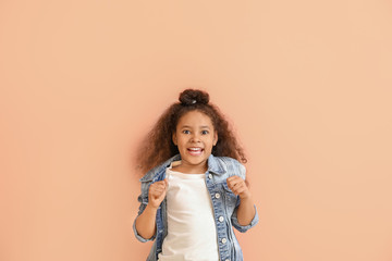 Happy African-American girl on color background